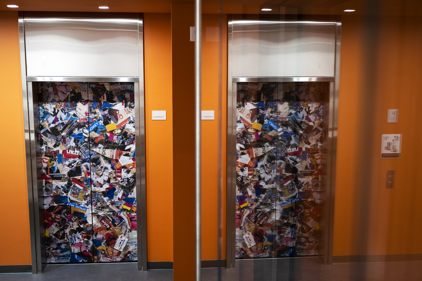 Multiple colored papers on elevator doors surrounded by orange walls are part of Snell Library's new look. 