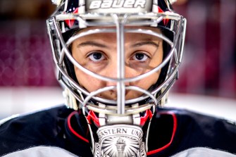 Gwyn Philips wearing her hockey goalie mask stares into the camera