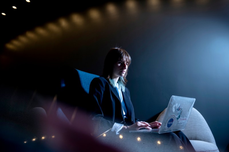 student working on laptop in dimly lit room