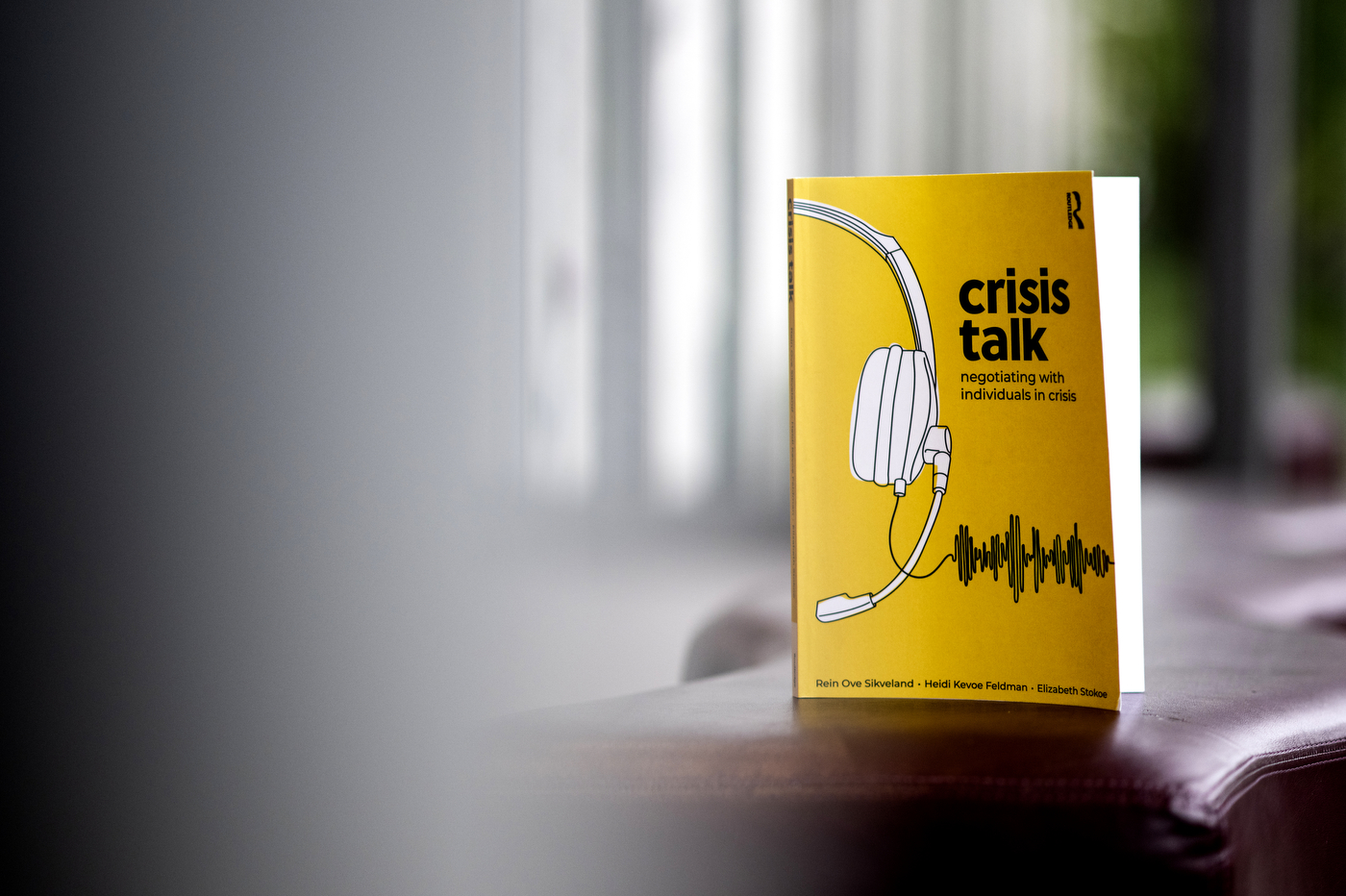 A book with the title "Crisis Talk" stands up on a table