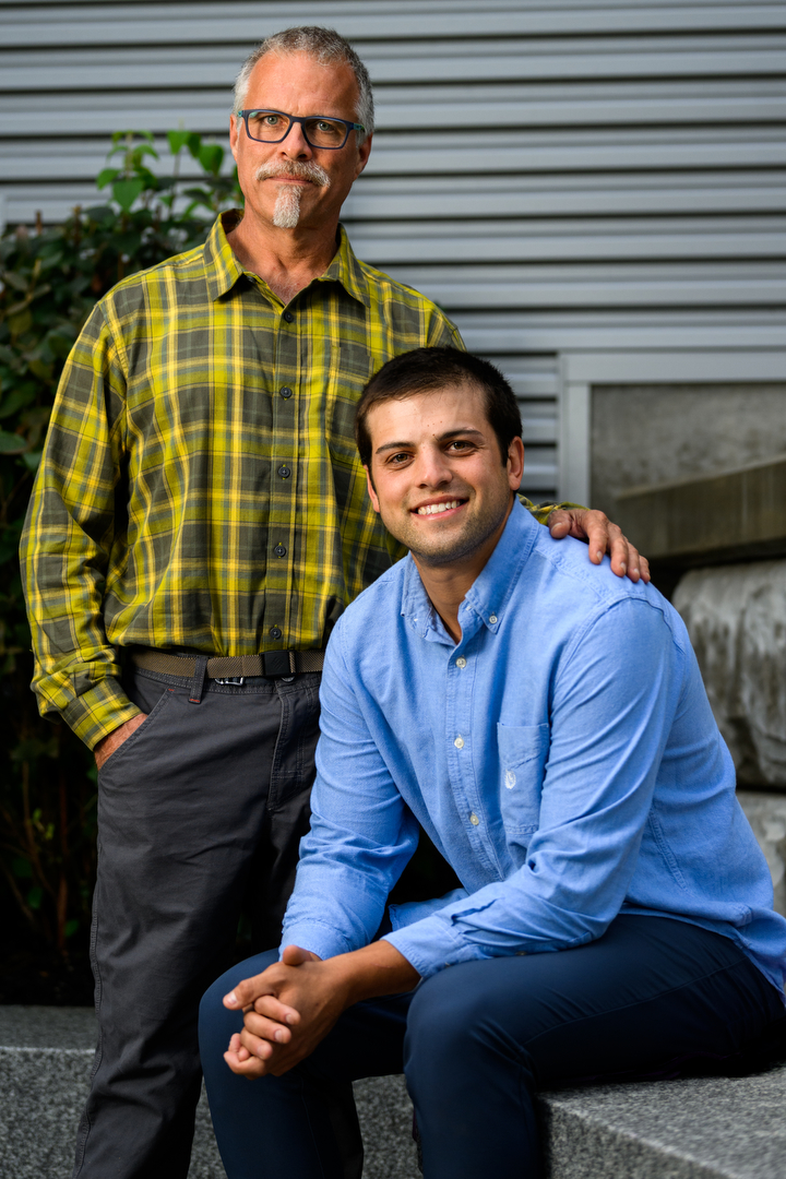 Ray Harvest (left) poses with his hand on the shoulder of his son Noah Harvest (right)