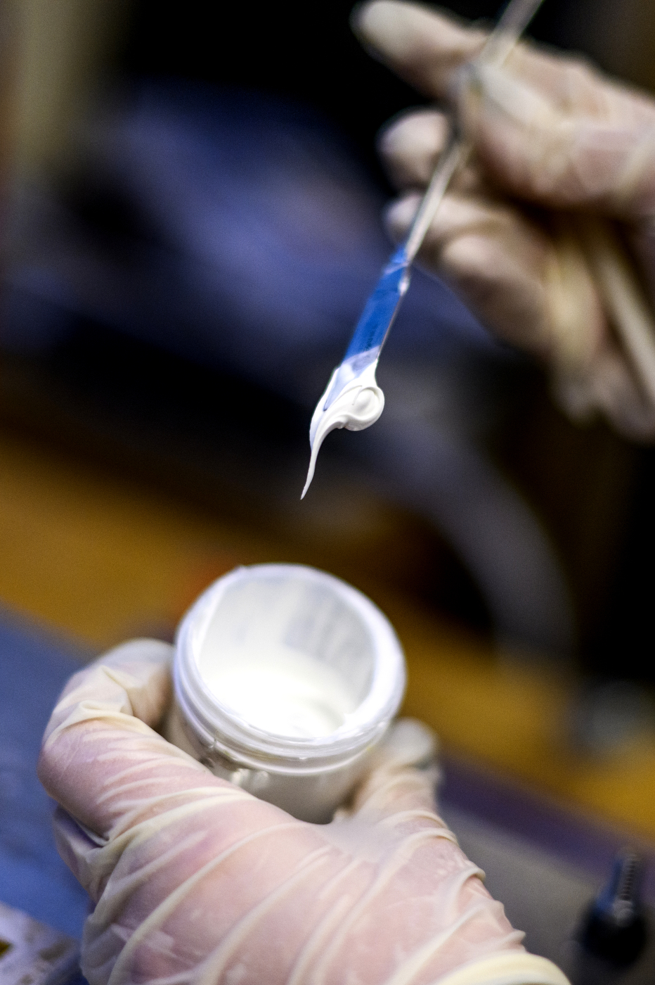 White paste removed from a small container with a brush