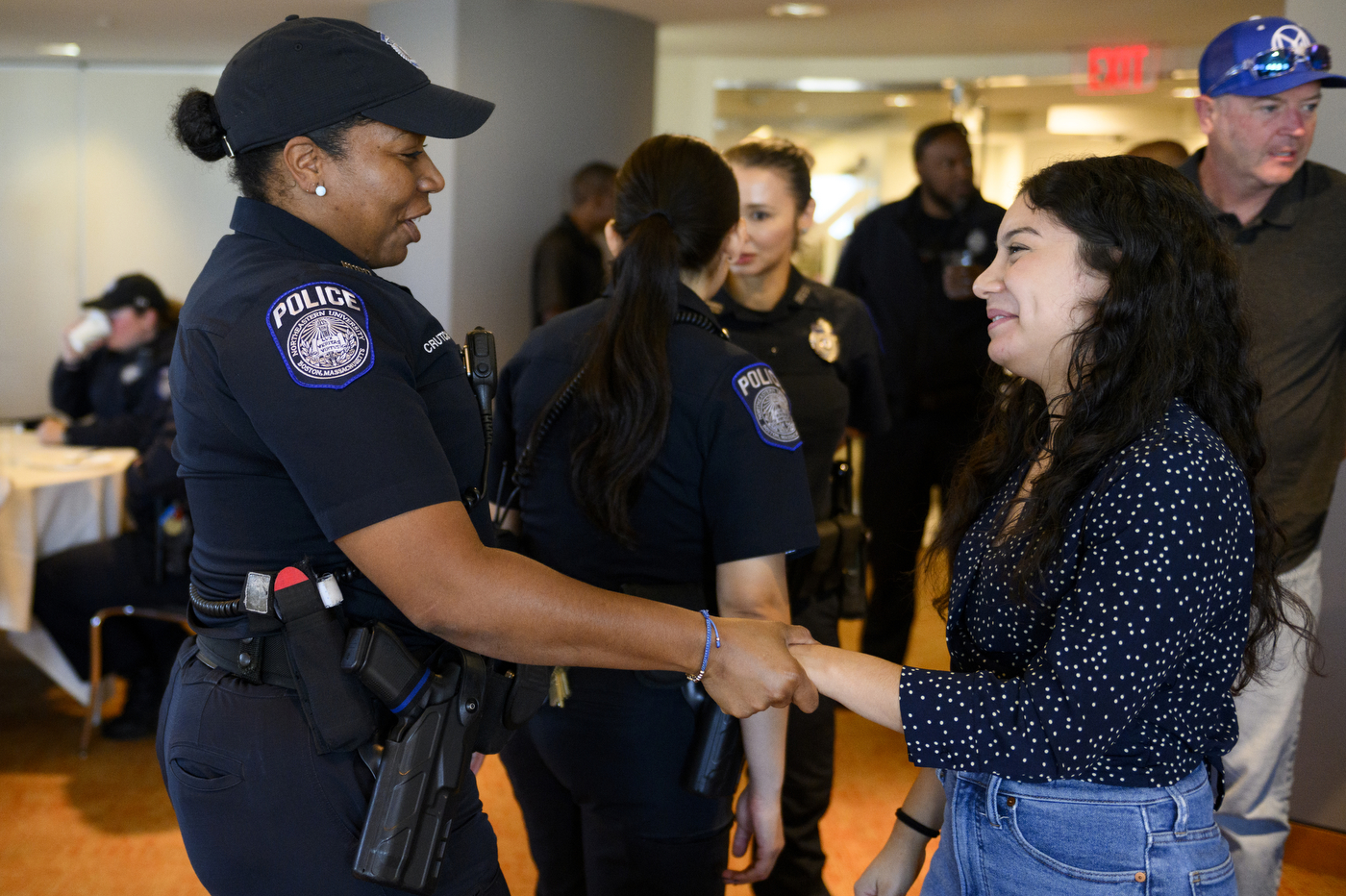 A person part of NUPD's police mentorship program is shaking hands with a police officer. 