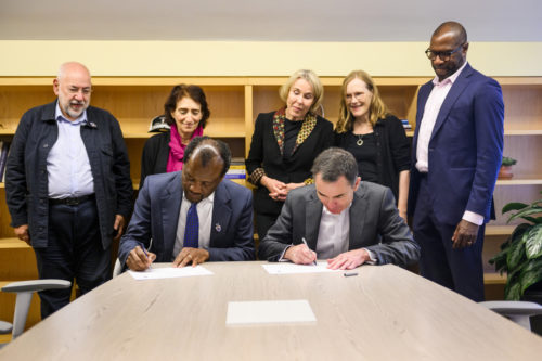 Northeastern Provost and Senior Vice President for Academic Affairs David Madigan (front right) and Zeblon Zenzele Vilakazi, vice chancellor of University of Witwatersrand in Johannesburg, South Africa, sign a memorandum of understanding, while Barry Dwolatzky, director of innovation strategy at Wits, from left, Hazel Sive, dean of the College of Science, Helen Rees, founder and executive director of Wits’ Reproductive Health and HIV Institute, Uta Poiger, dean of the College of Social Science and Humanities, and James Hackney, dean of the School of Law, observe. Photo by Matthew Modoono/Northeastern University