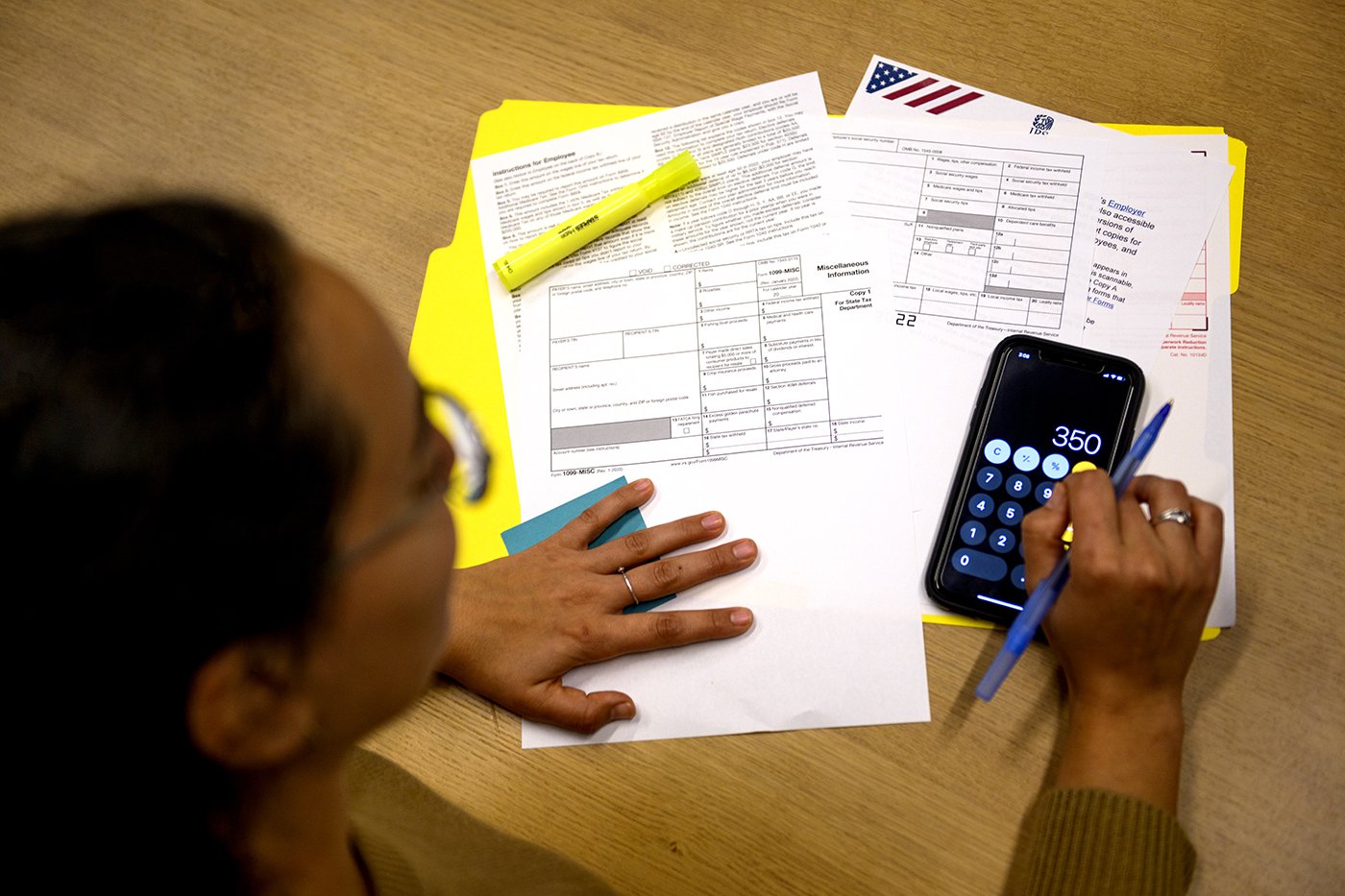 Woman filling out paperwork using a calculator