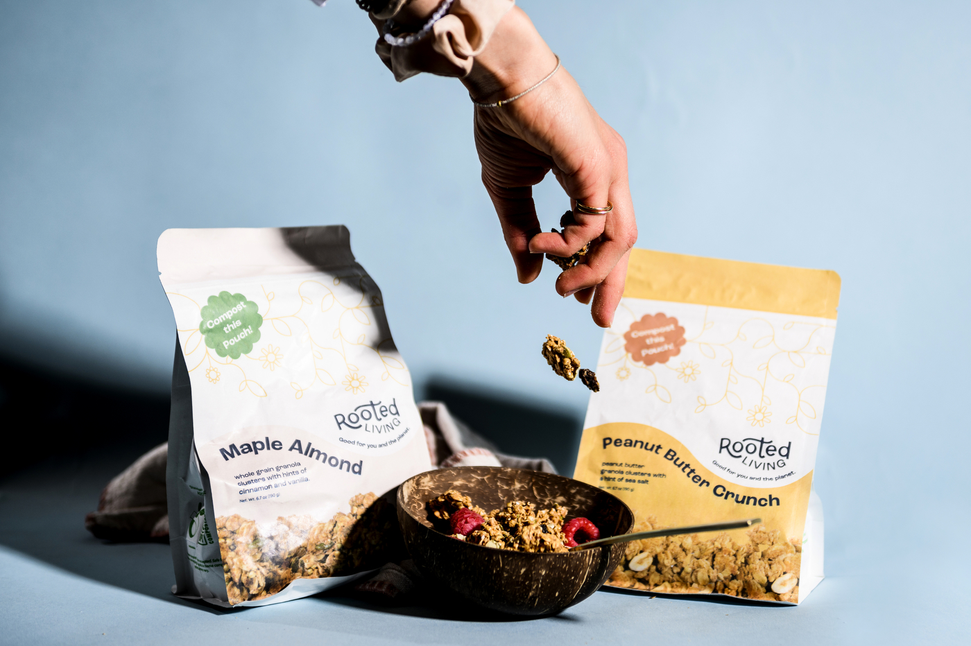 hand reaching for package of rooted living granola