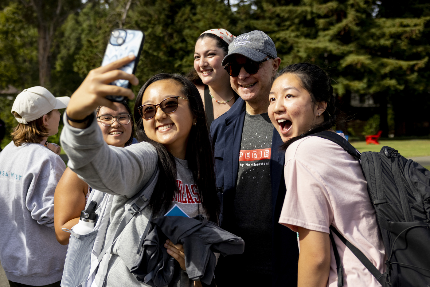 two students pose for a selfie with President Aoun