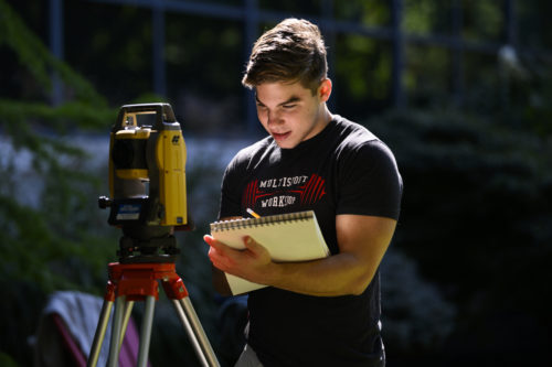 Civil engineering student Tommy Zuccarello practices surveying in the Northeastern arboretum as part of his materials lab. Photo by Alyssa Stone/Northeastern University
