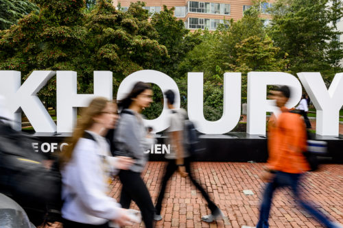 Northeastern students walk past new branding outside the Khoury College of Computer Sciences. Photo by Matthew Modoono/Northeastern University