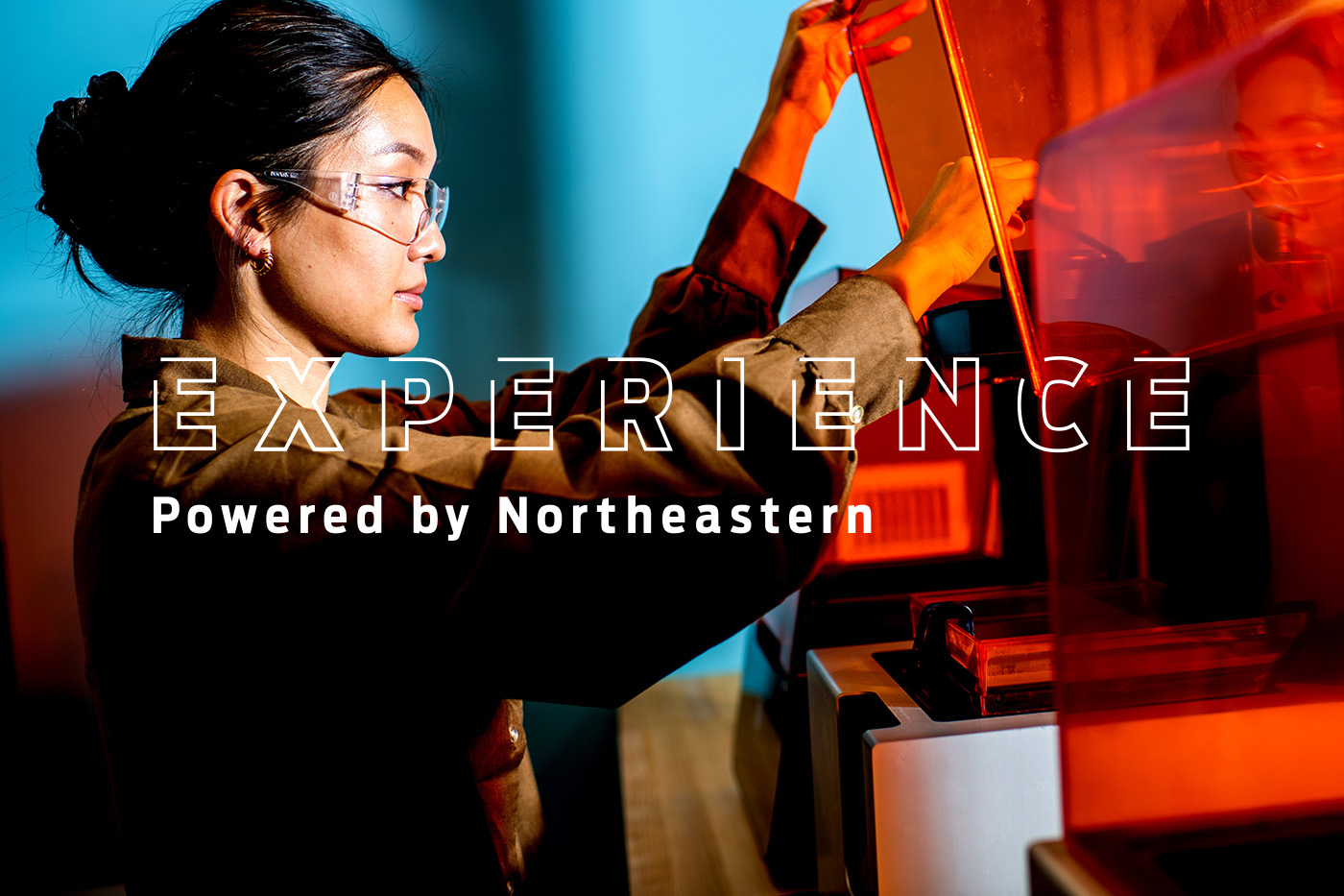 A student wearing goggles working in the lab, overlaid by the text EXPERIENCE Powered by Northeastern