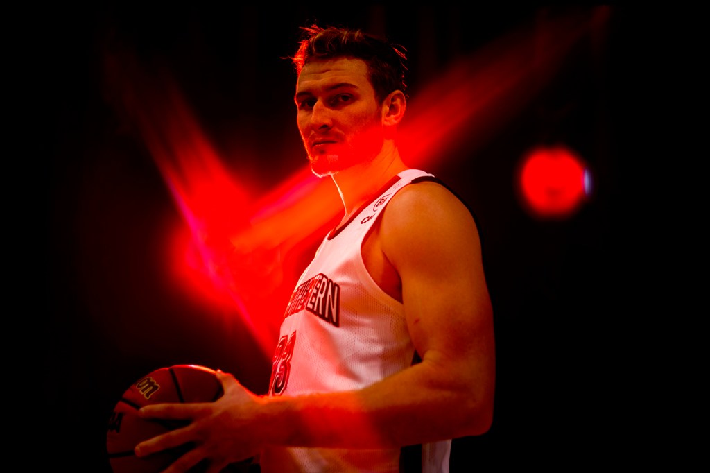 basketball player holding basketball under red lights