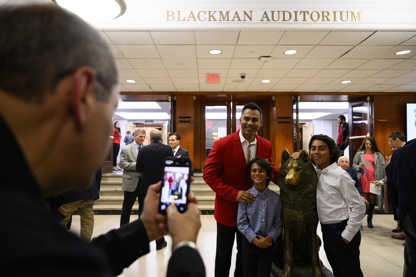 Carlos Peña poses with his two sons for a photo with Northeastern's golden husky statue 