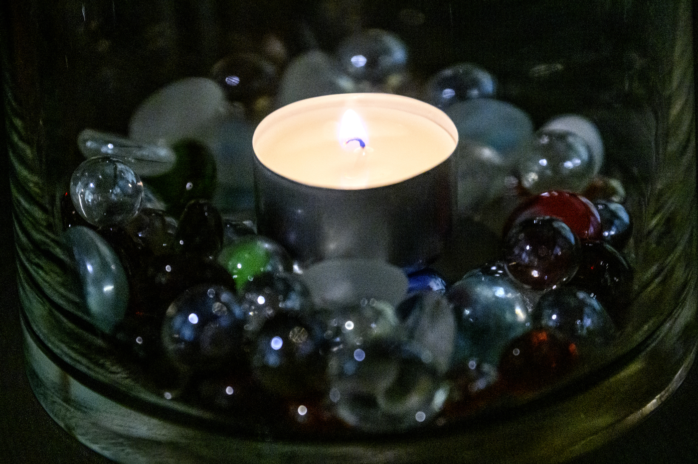 Candle surrounded by shiny rocks