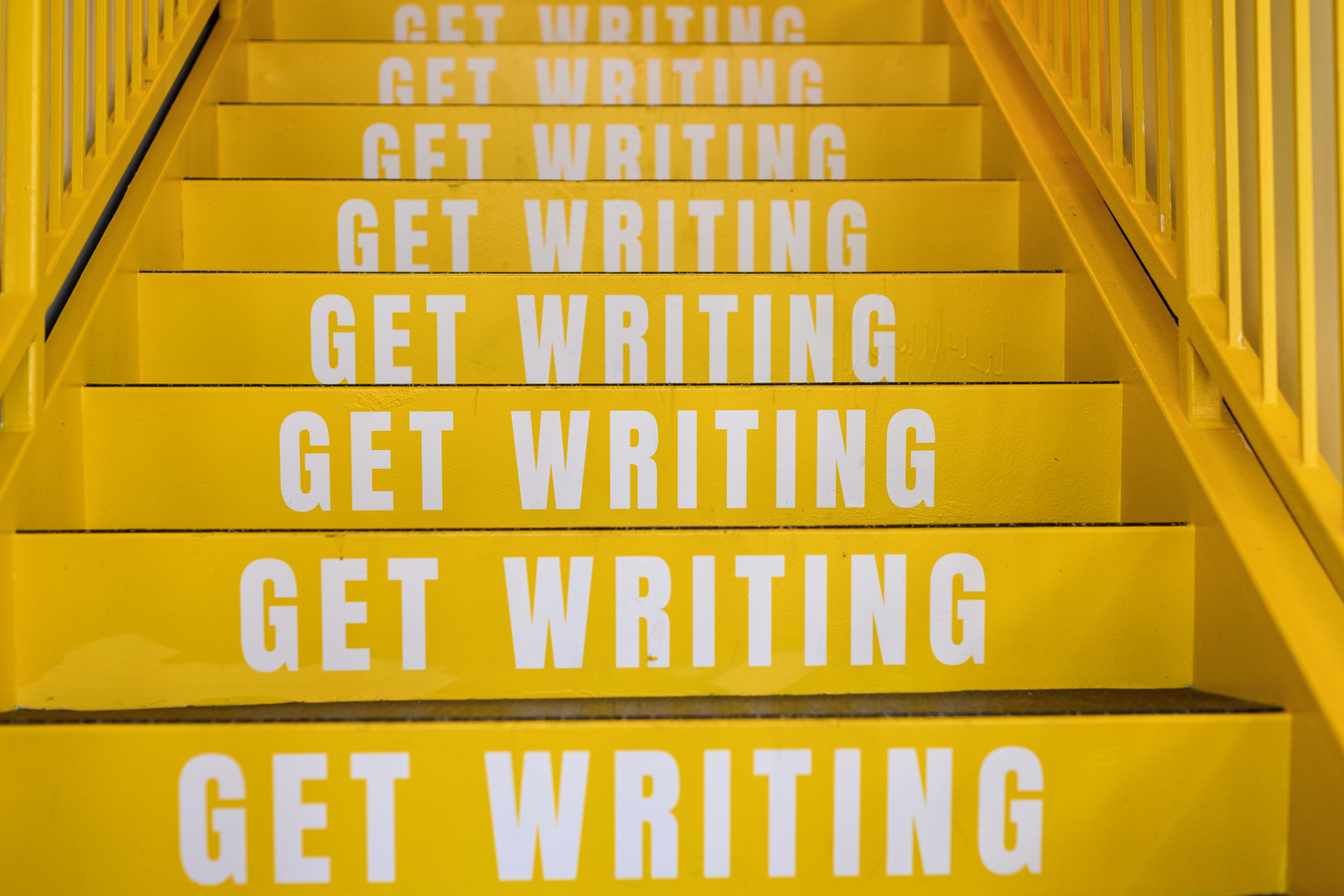 yellow stairs with white text on them saying 'get writing' in all caps