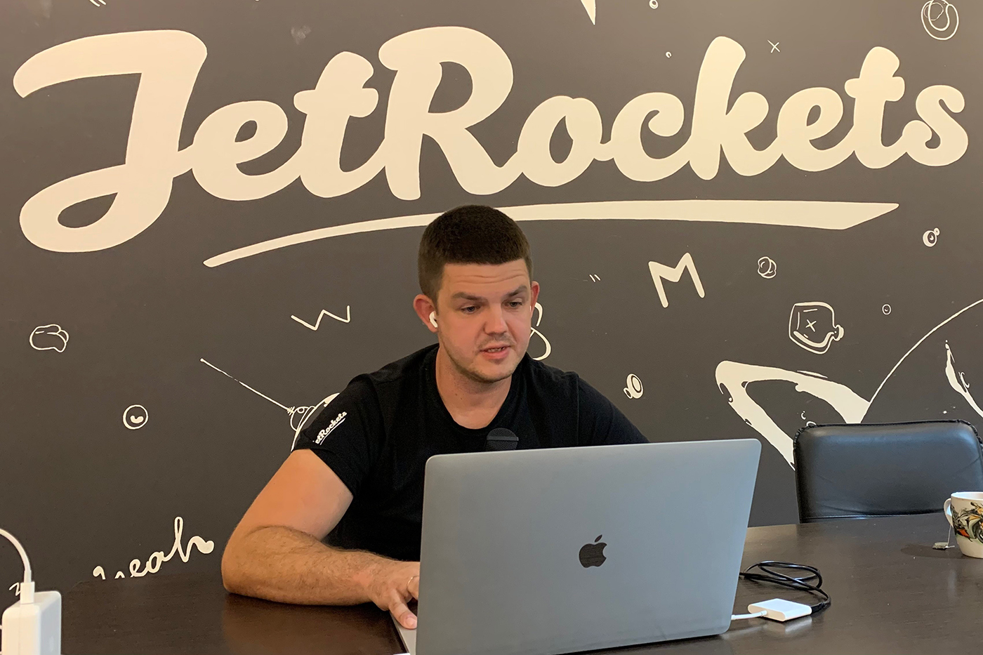 person working on laptop in front of jetrockets logo