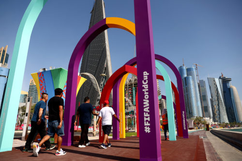 people walking next to colorful structures in qatar