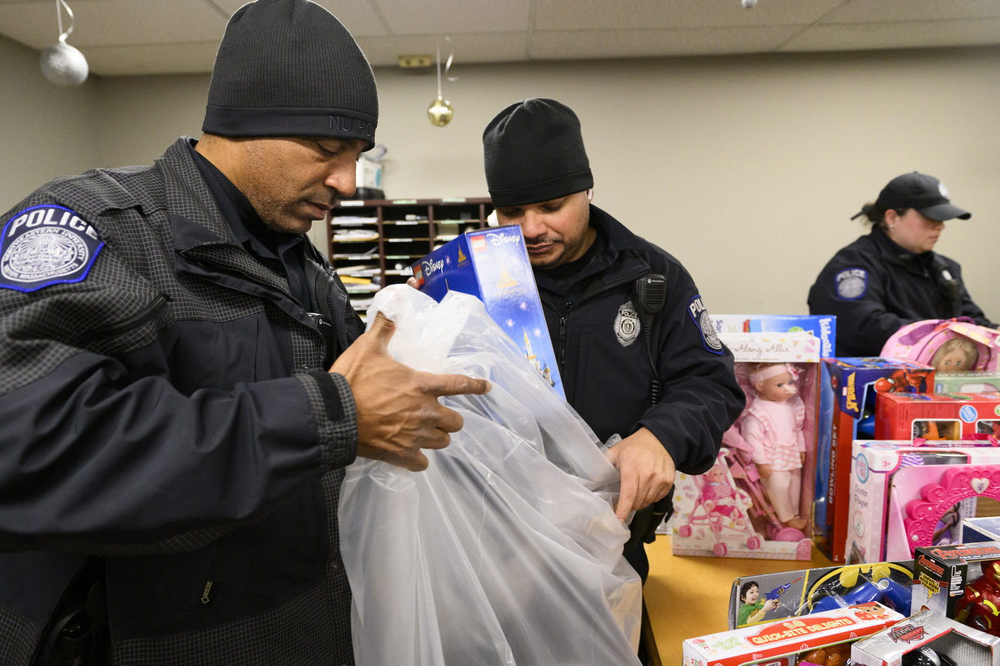 police officer sorting toys into garbage bags