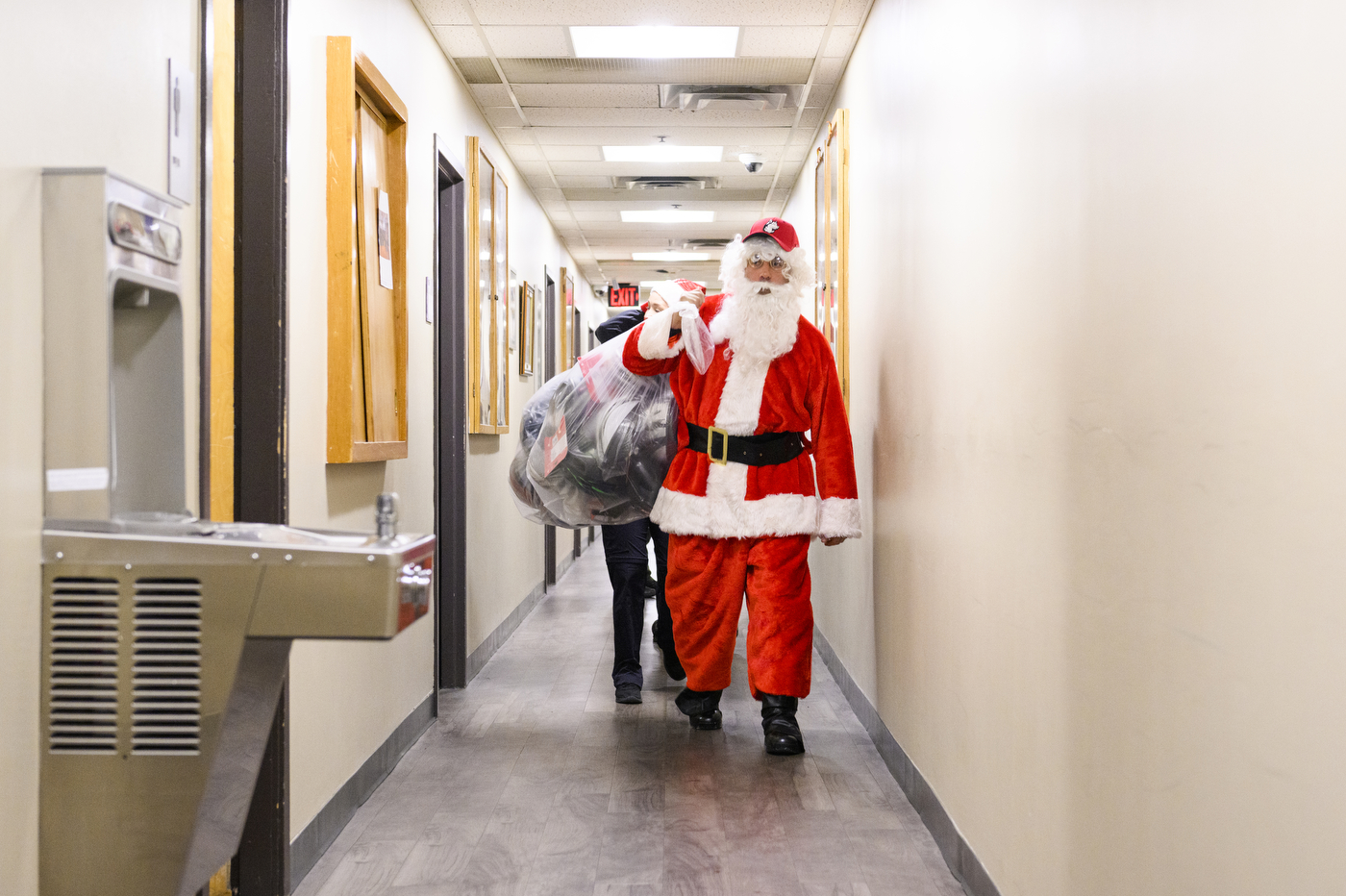 person dressed up as santa claus holding bag full of toys