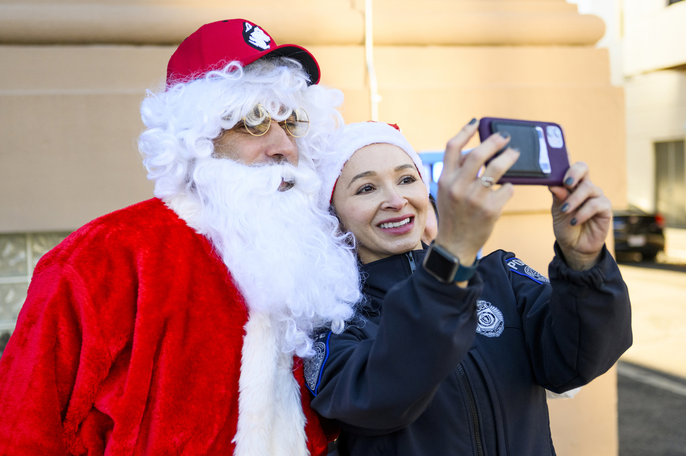 police officer taking a selfie with person dressed up as santa claus
