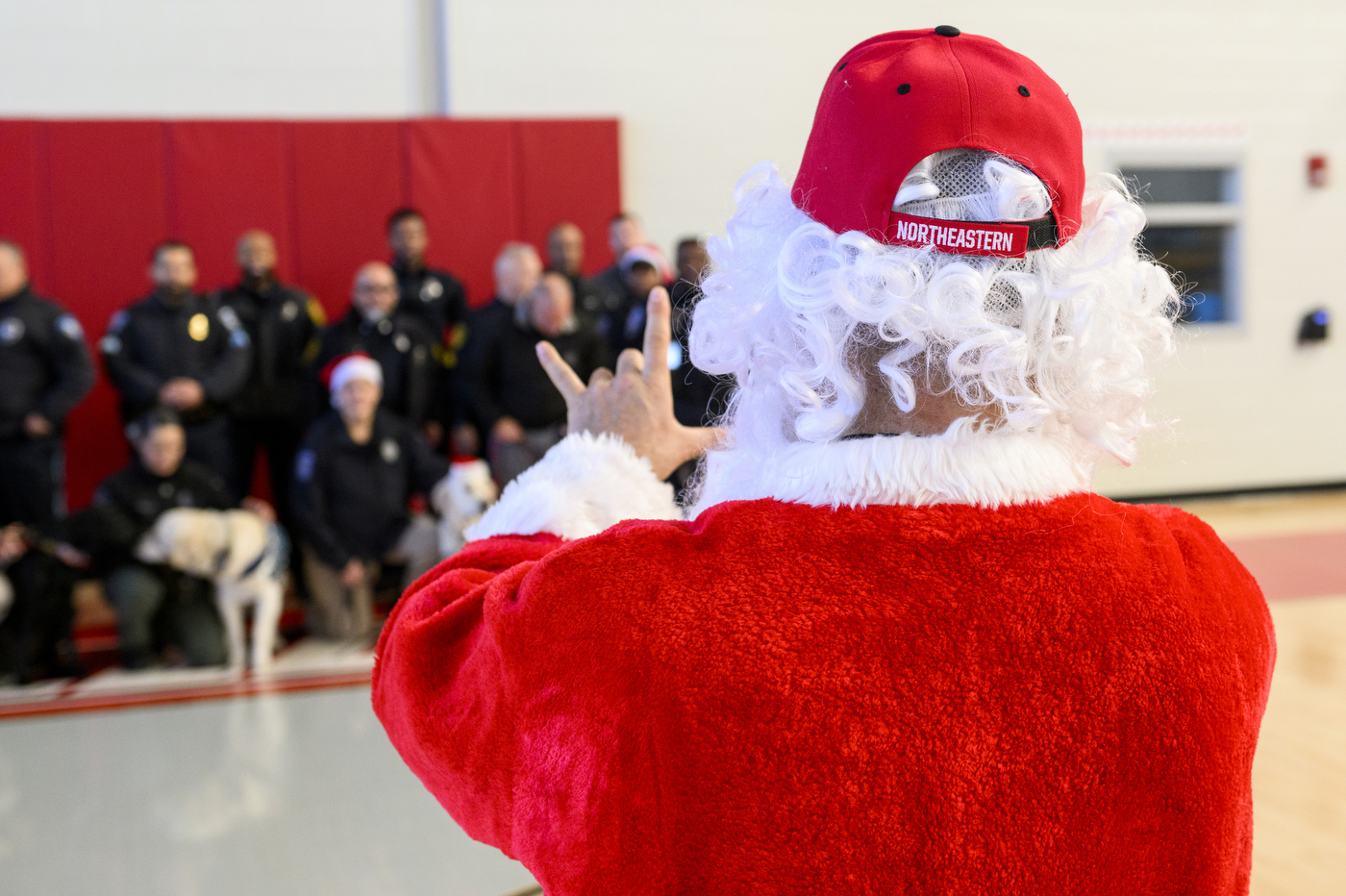 person dressed up as santa claus taking photo of police officers