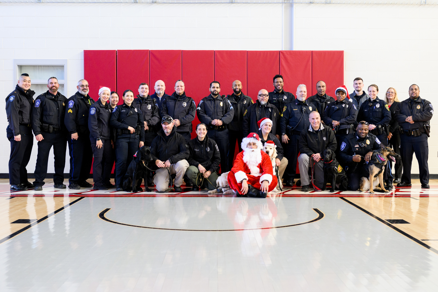 group of police officers and person dressed up as santa posing for a photo
