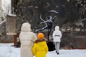 people looking at banksy mural
