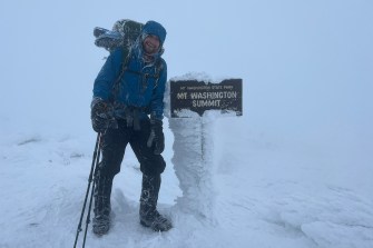 scott benerofe posing next to mt washington summit trail sign