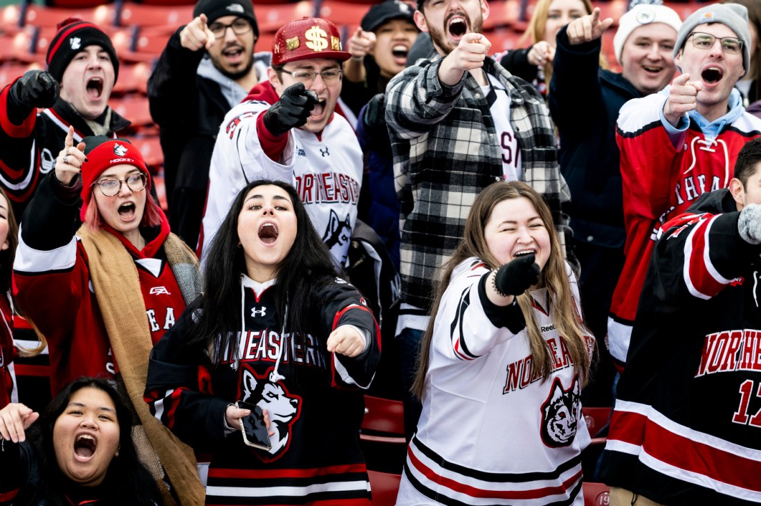 Northeastern community members pointing and yelling at a Frozen Fenway game. 