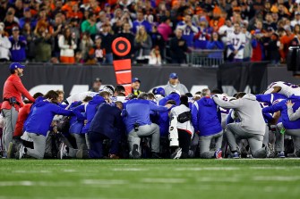 football players kneeling in solidarity on the field