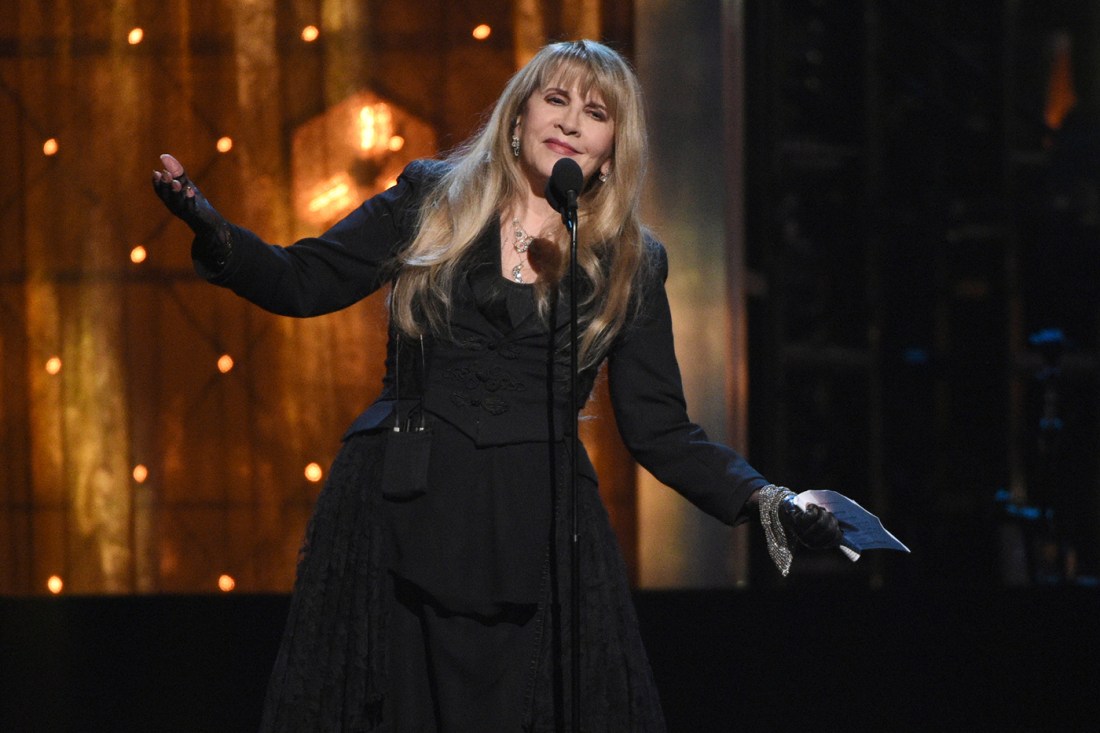 Stevie Nicks in front of the microphone on stage, swaying to the music