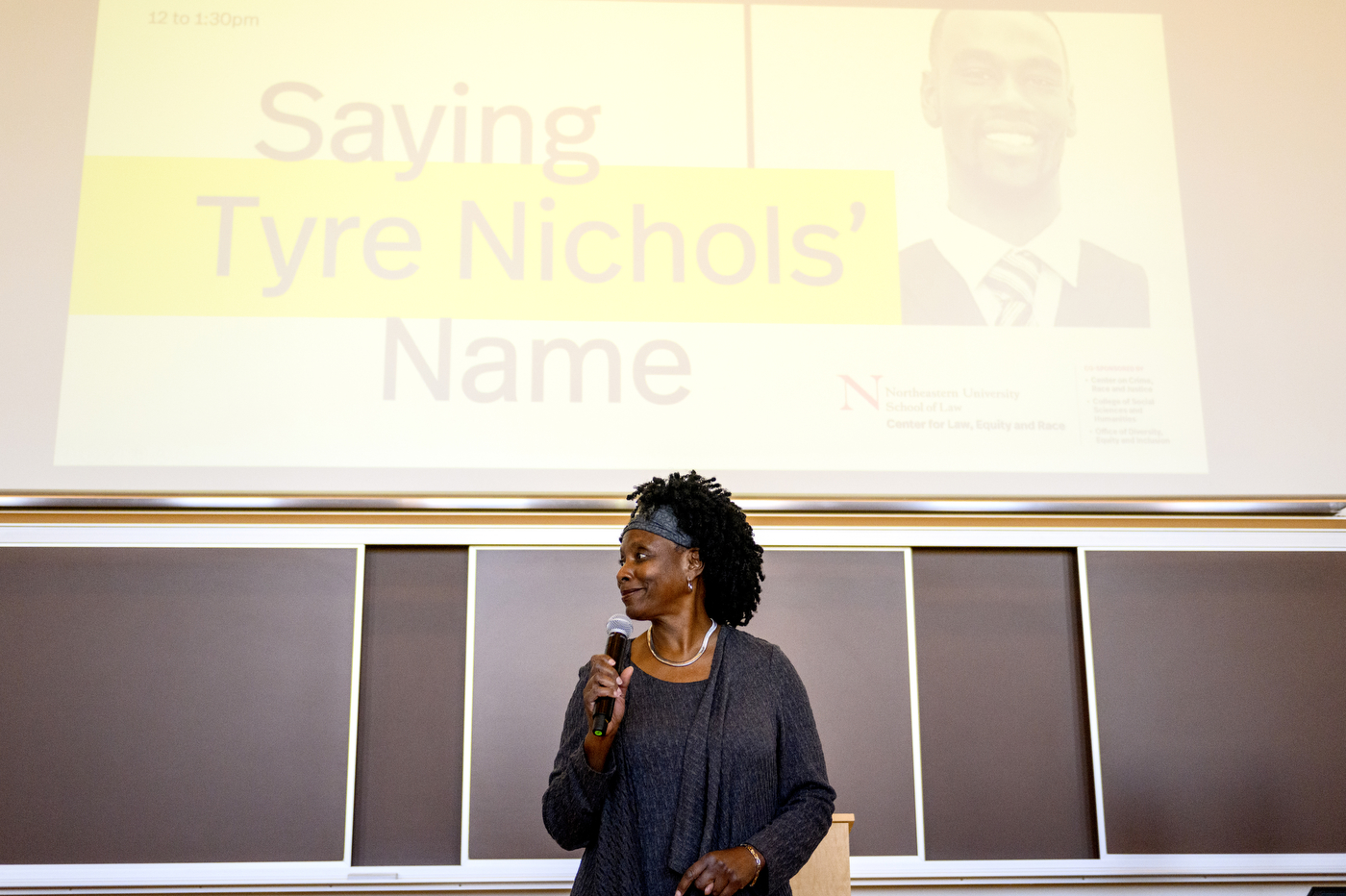 person holding microphone in front of powerpoint display sbout tyre nichols