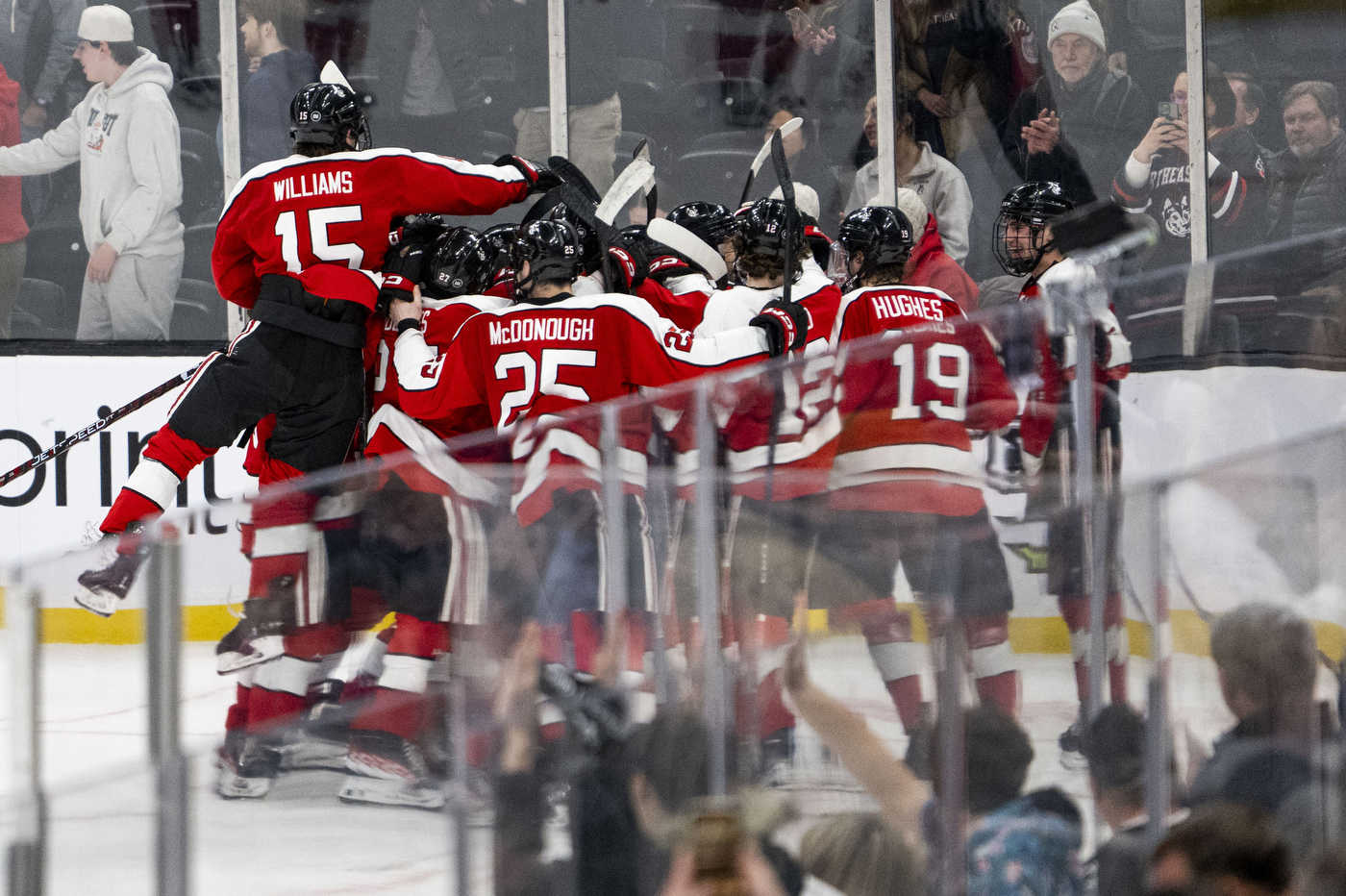 northeastern hockey players cheering after scoring a goal