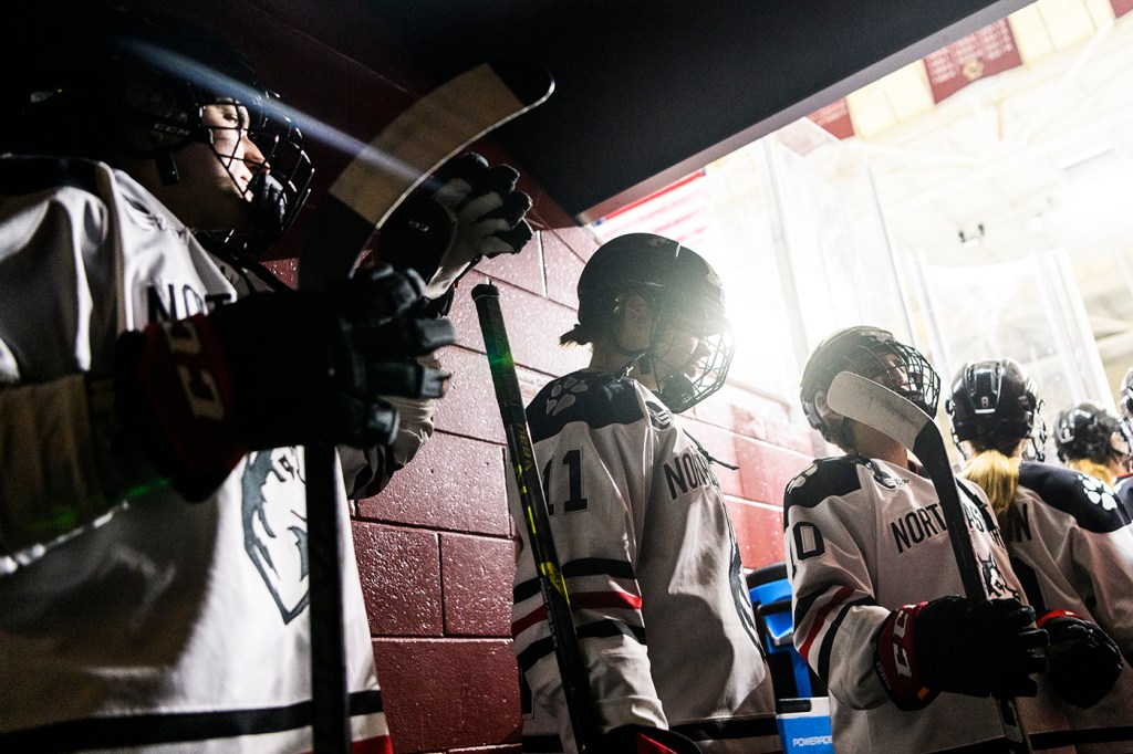 Women's hockey players wait in line to enter the ice
