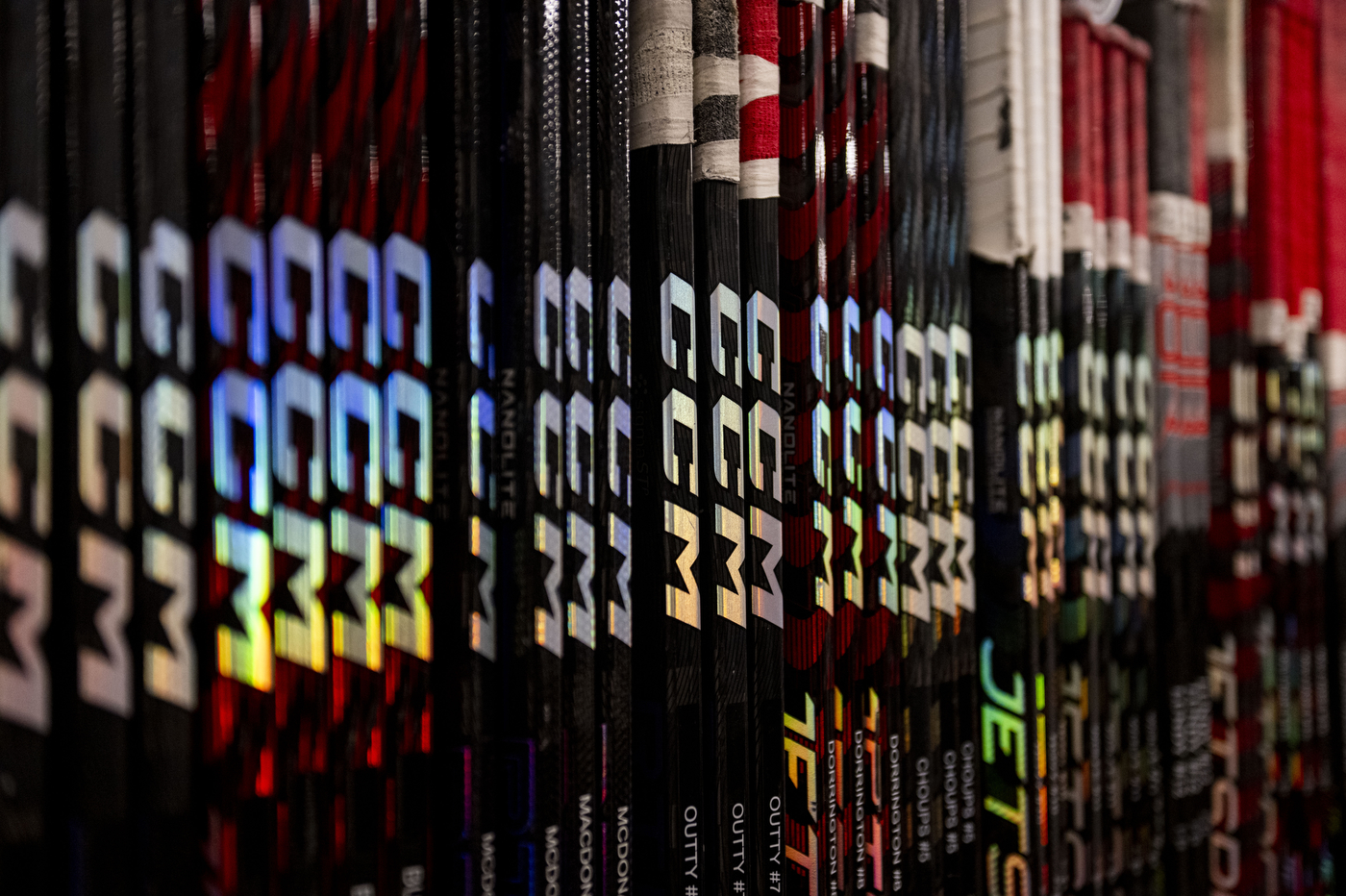 hockey sticks lined up against the wall