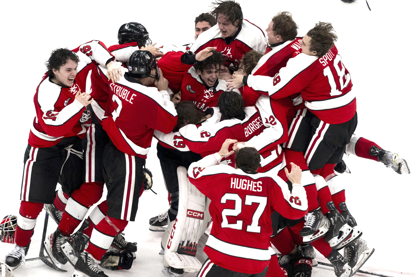 northeastern mens hockey team jumps on each other in celebration of winning the beanpot final