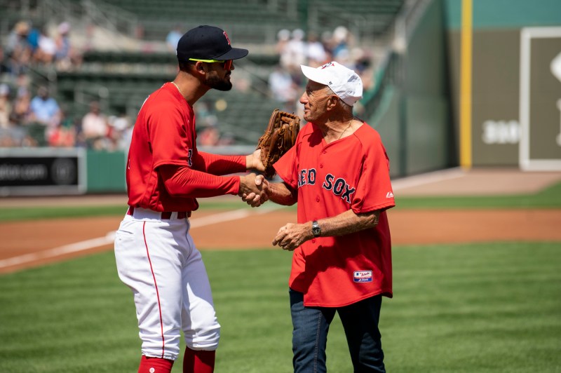 A Res Sox player shakes the hand of a person wearing a Red Sox jersey