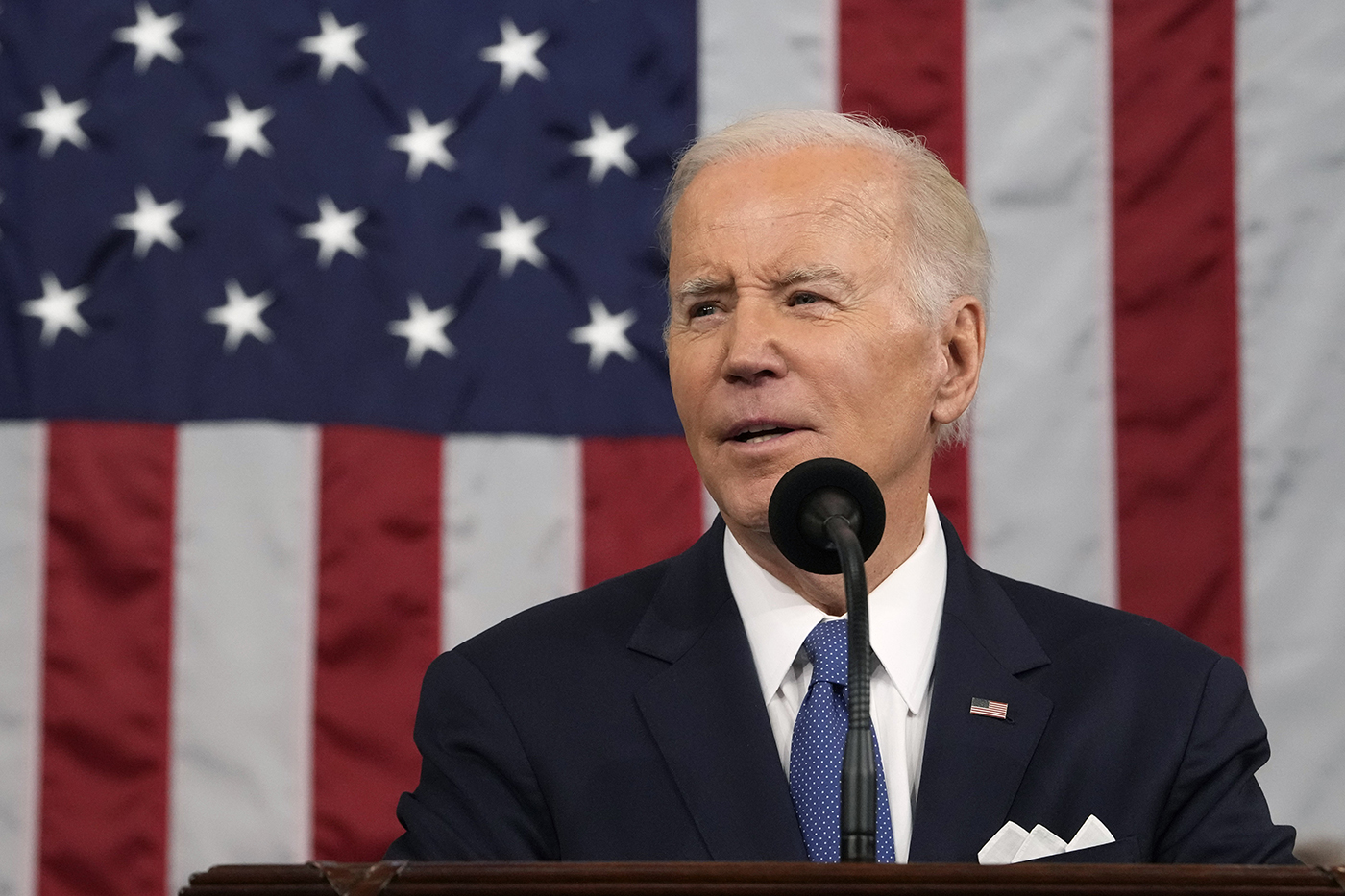 president biden speaking into microphone delivering the state of the union address