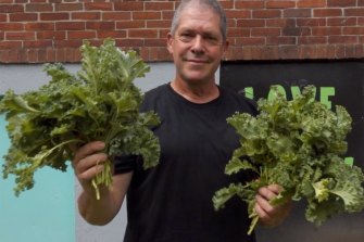 George Benner holds up greens that were grown in the Urban Garden.
