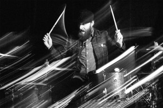 A stylized, black and white photo of Jonathan Ulman drumming