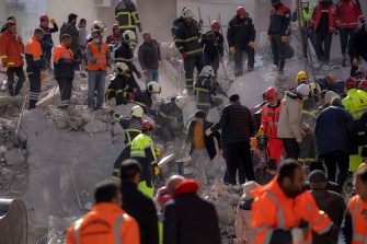 Firefighters and rescue teams searching for people in rubble
