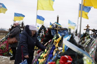 A crowd of people hold Ukrainian flags