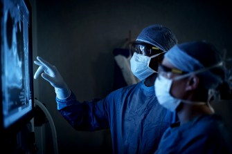 two medical professionals look at a medical image on a screen