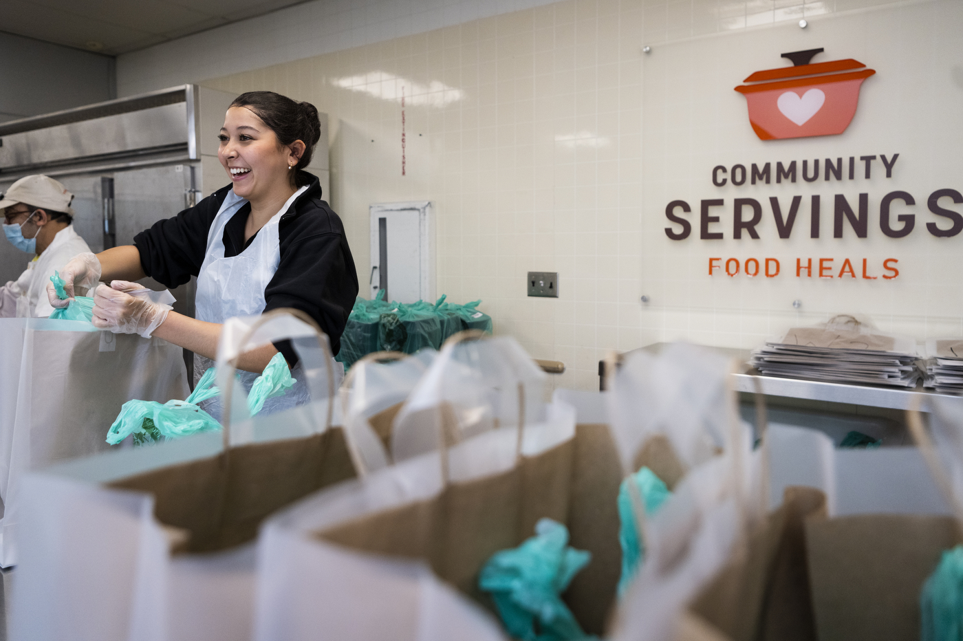 Carina Davis filling bags with food at Community Servings in Jamaica Plain