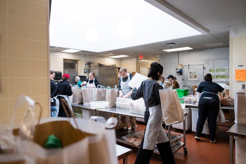 students filling bags with food at Community Servings in Jamaica Plain