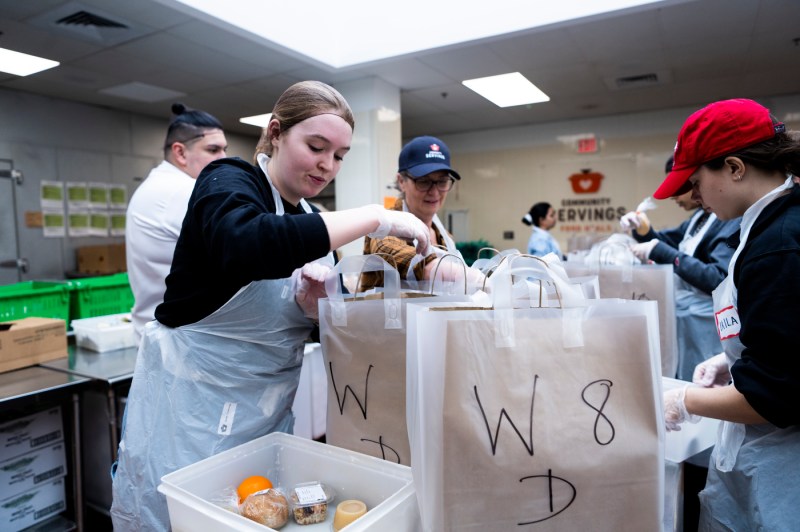student filling bags with food at Community Servings in Jamaica Plain