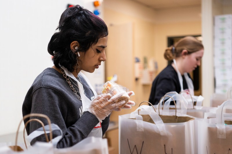 student filling bags with food at Community Servings in Jamaica Plain
