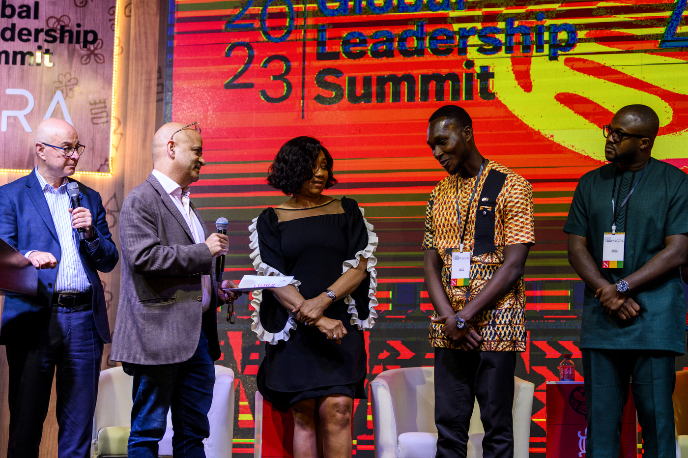 Subodh Chanrai presenting scholarship to Kelvin Amakye on stage at Global Leadership Summit