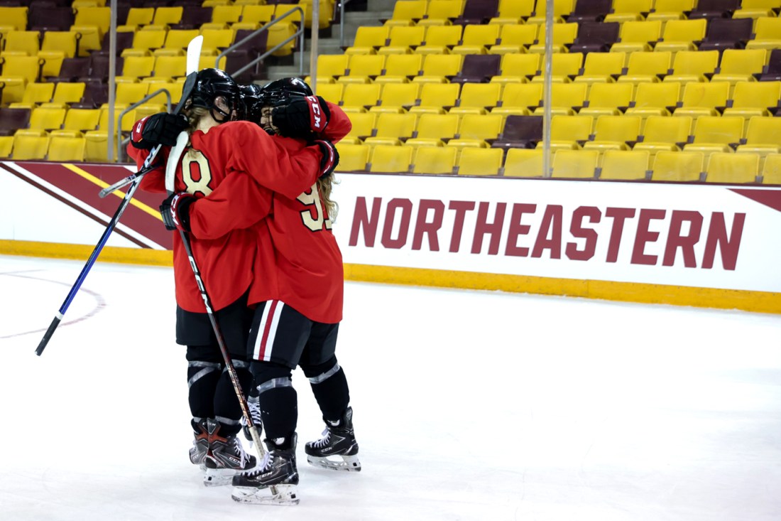 womens hockey players hug each other on the ice