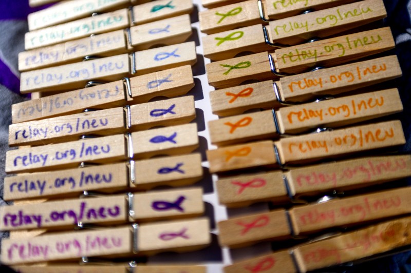 a line of clothespins with the relay for life Northeastern webpage link written on them