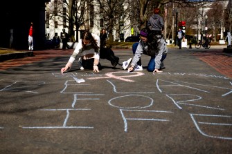 students drawing "relay for life" with chalk on the Boston campus